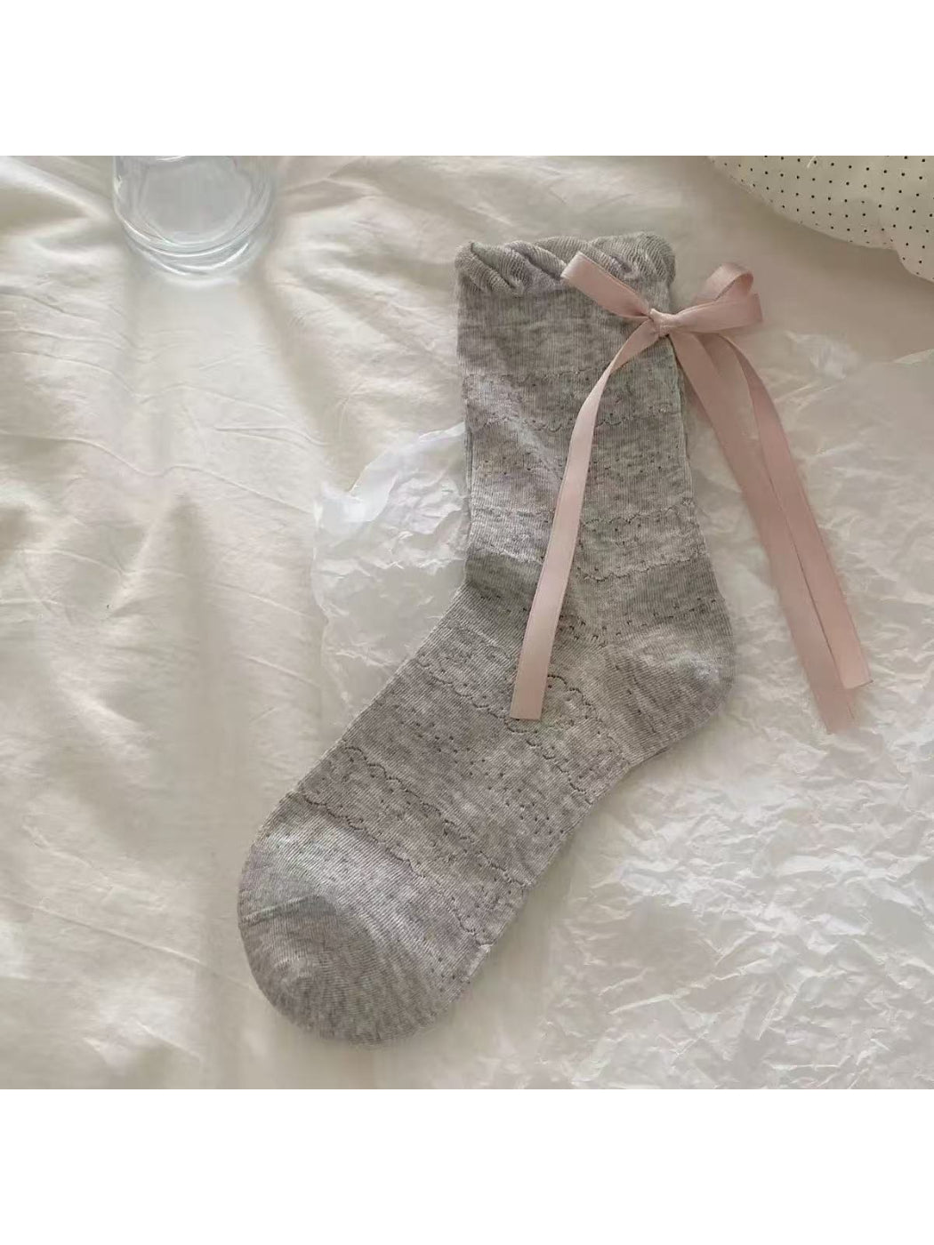 Rufia Romantic Bow Texture crew socks displayed on a wooden surface with soft light