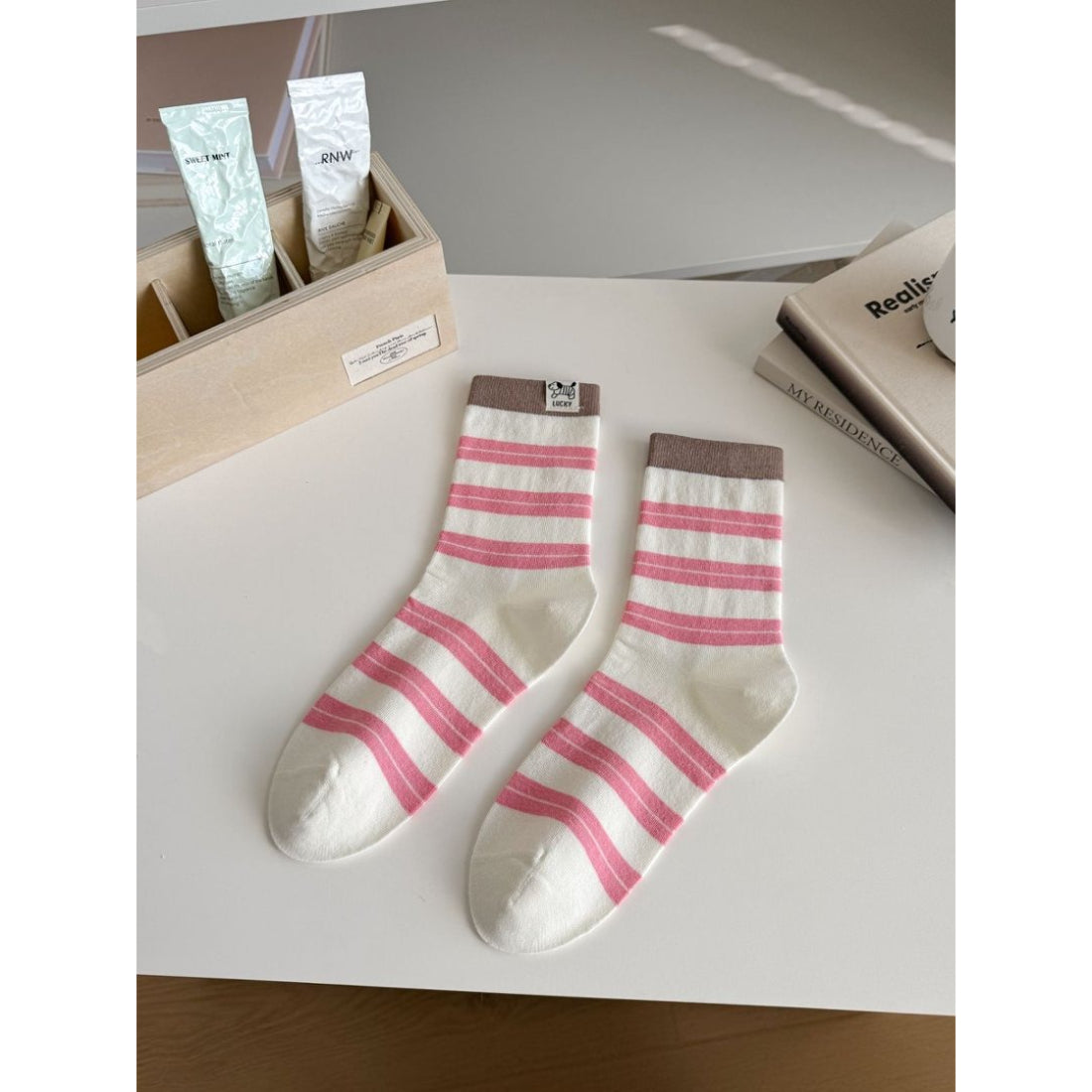 Pair of Rufia contrast stripe knit crew socks displayed on wooden surface