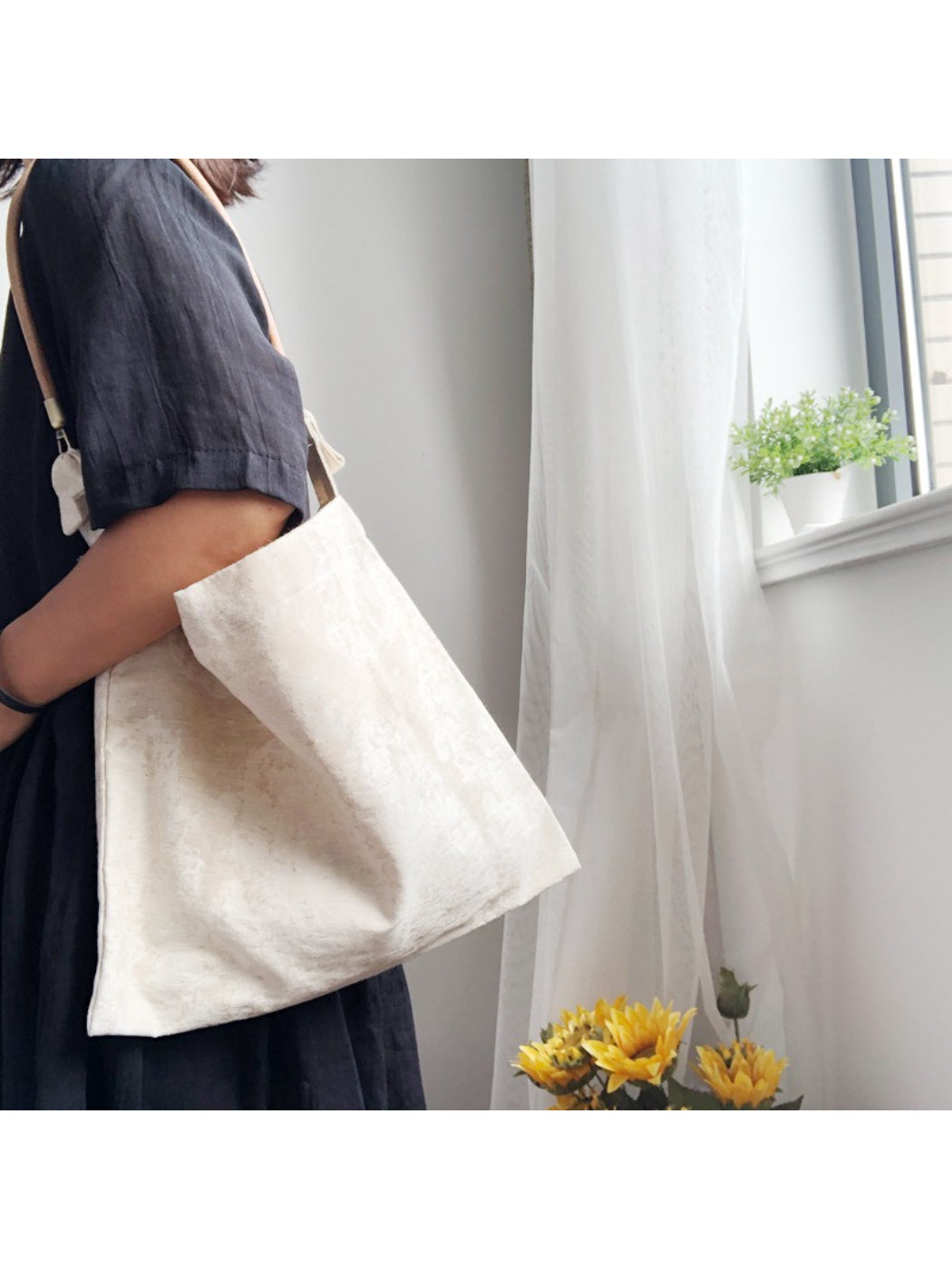 Ivory patterned hobo bag styled with casual outfit on a wooden surface