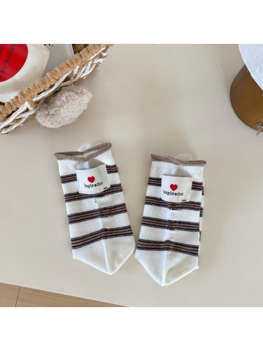 Rufia neutral crew socks paired with casual sneakers on a wooden floor