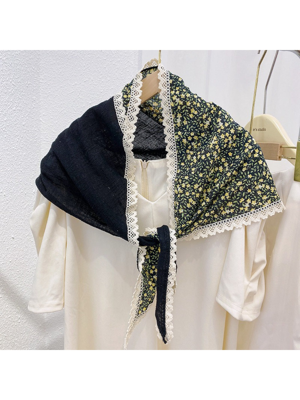 Scarvii triangle scarf folded to showcase lace texture and multicolor floral design