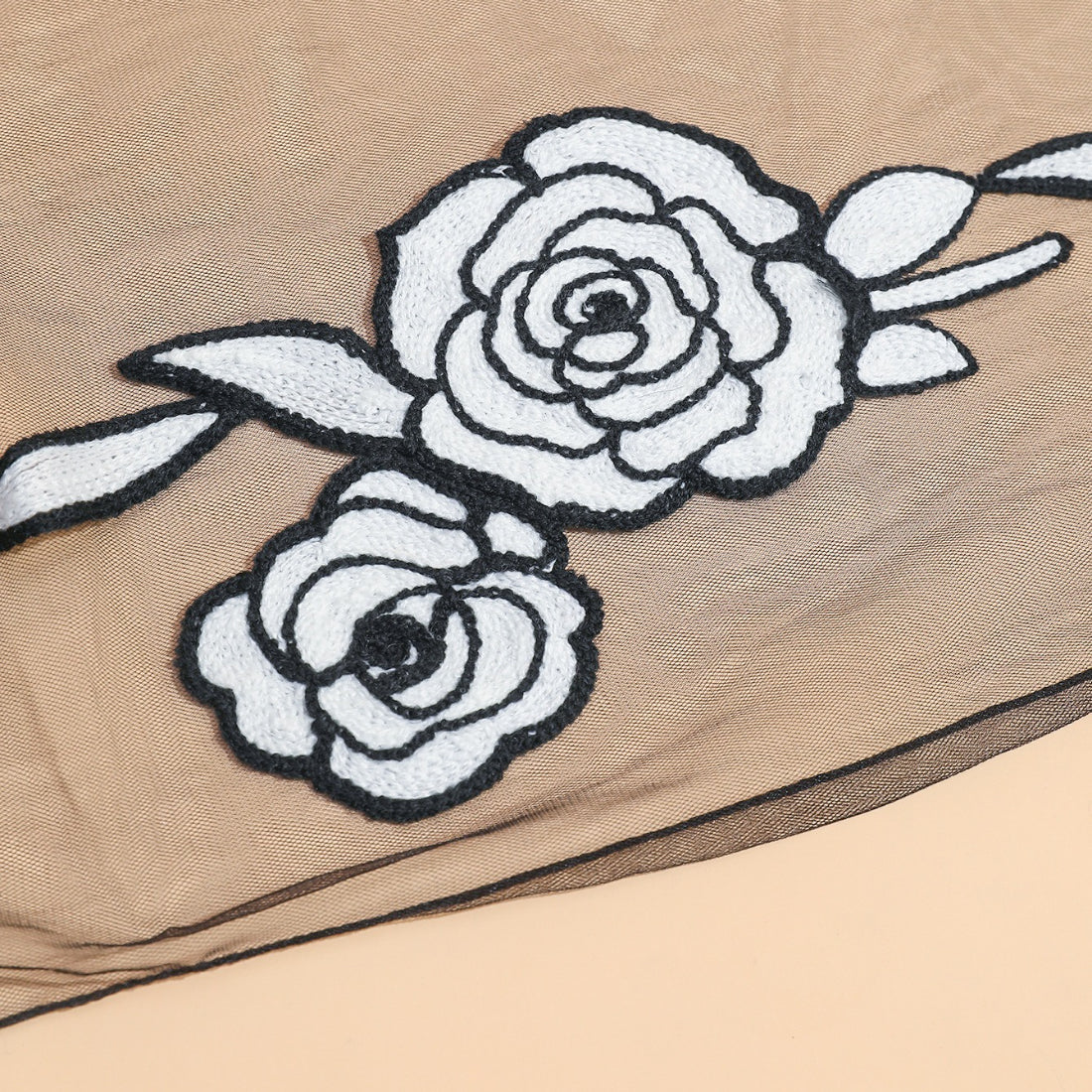 Folded sheer rose mesh scarf showing lightweight and translucent texture