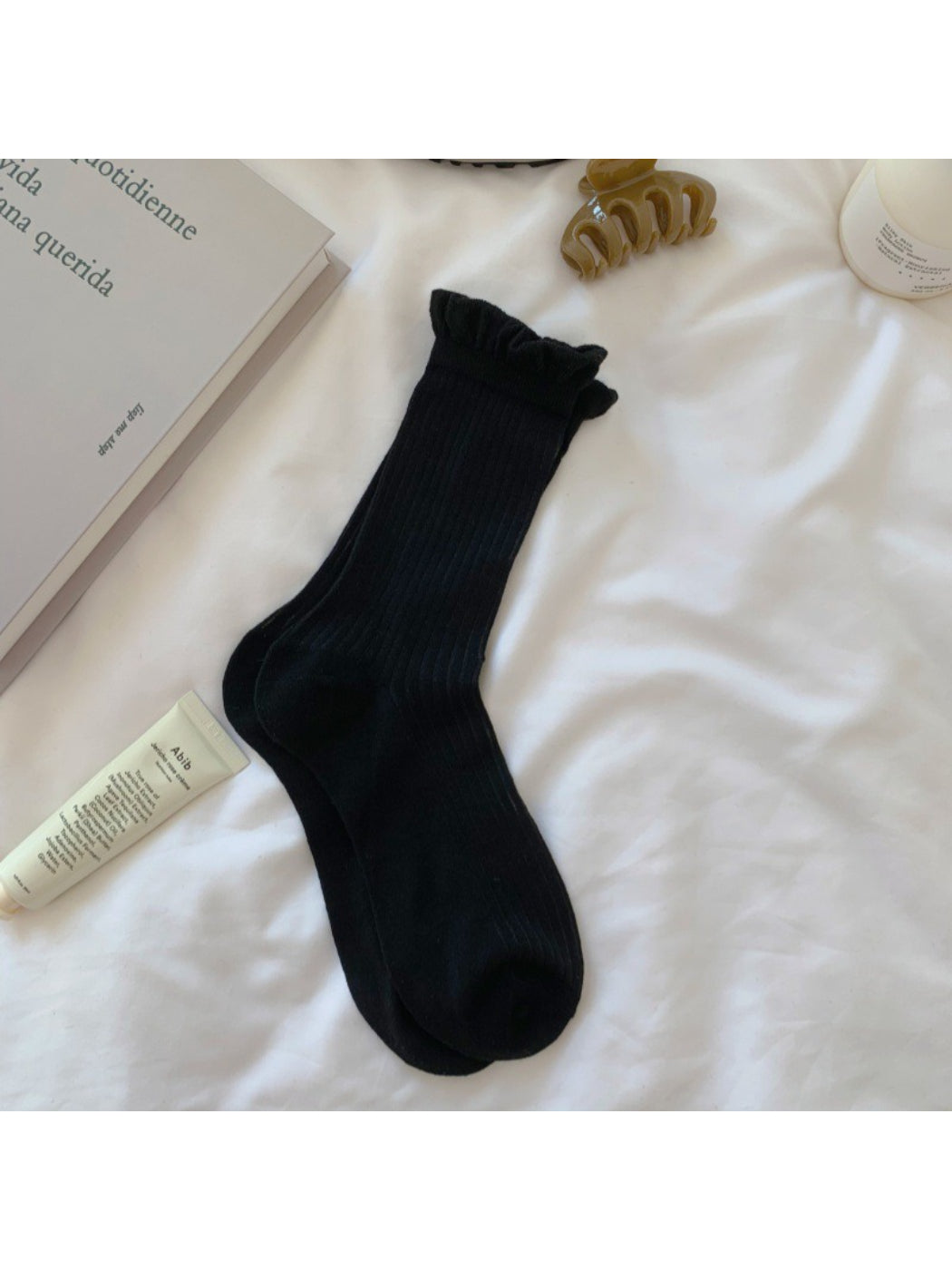 Rufia white crew socks displayed on wooden surface