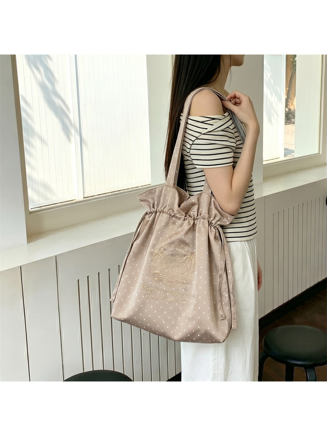 Cosbai drawstring shoulder bag with polka dot pattern styled with casual outfit