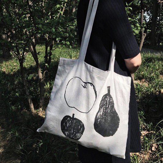 Close-up of vibrant fruit design featuring oranges and leaves on tote bag
