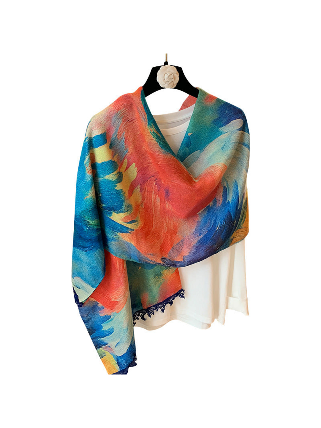 Blue scarf with coral, teal and yellow painterly swirls, draped asymmetrically over a white top