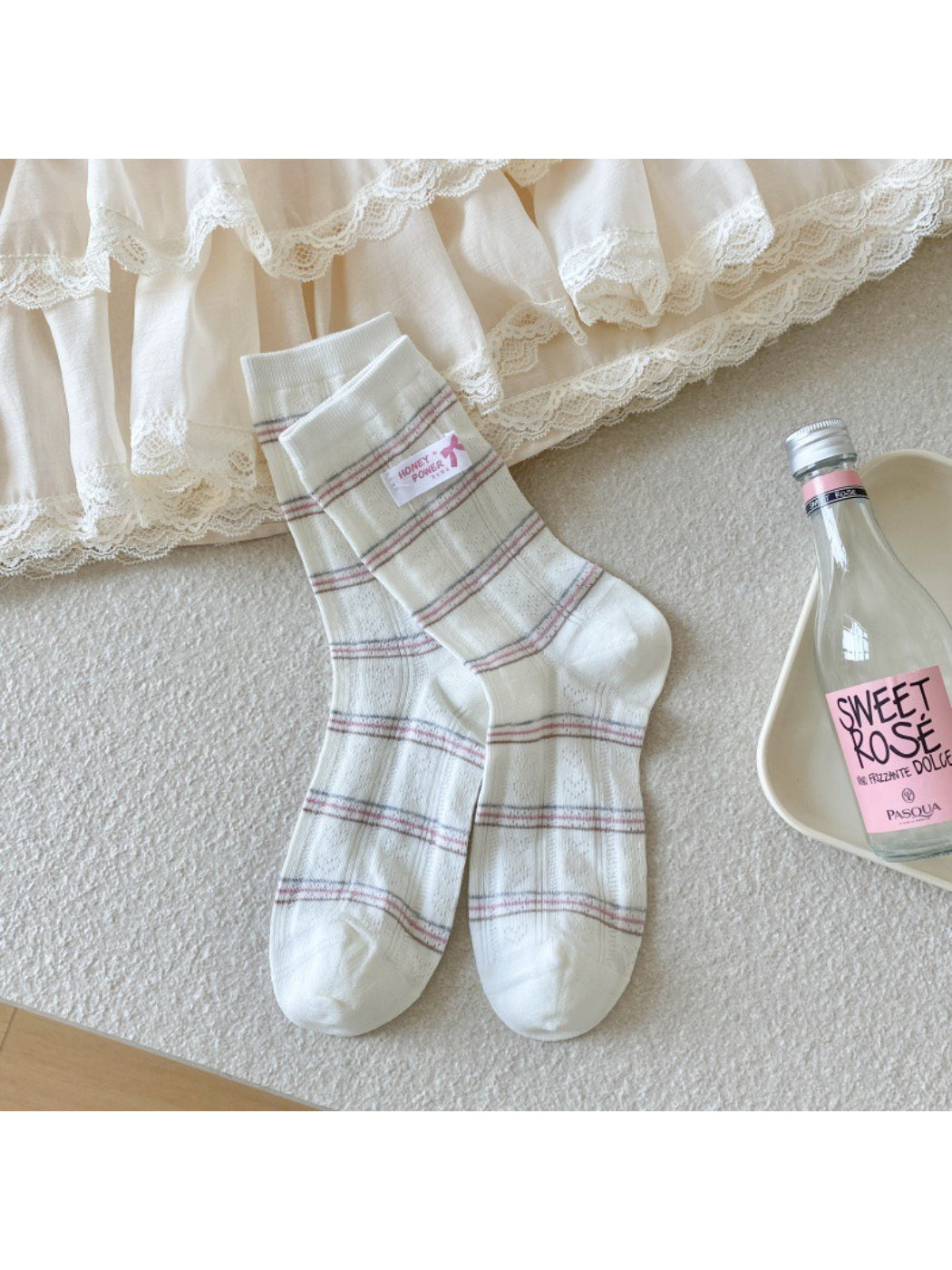 Pair of Rufia check crew socks with ribbon detail laid out on white background