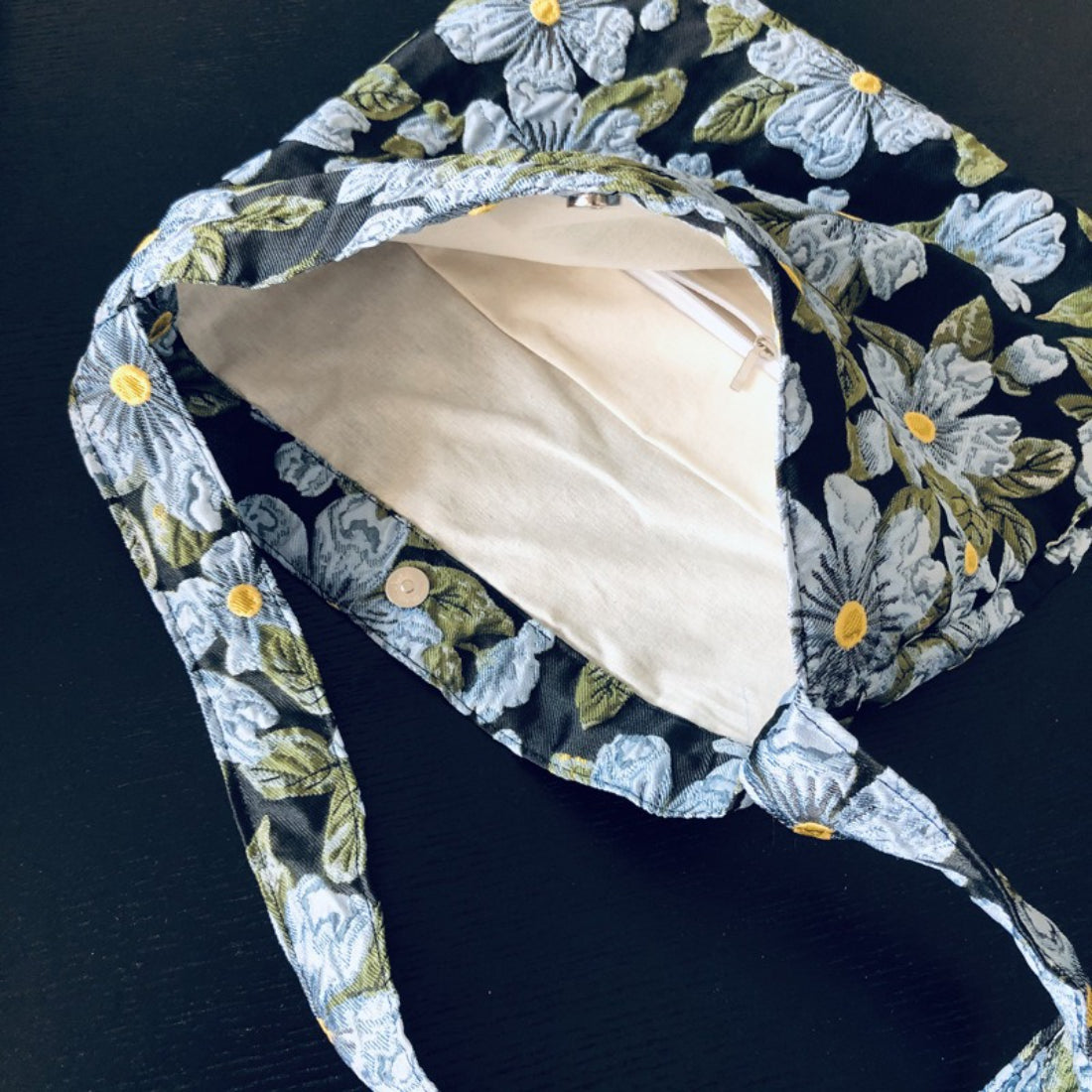 Cosbai Daisy Garden tote bag styled with casual outfit on a wooden surface