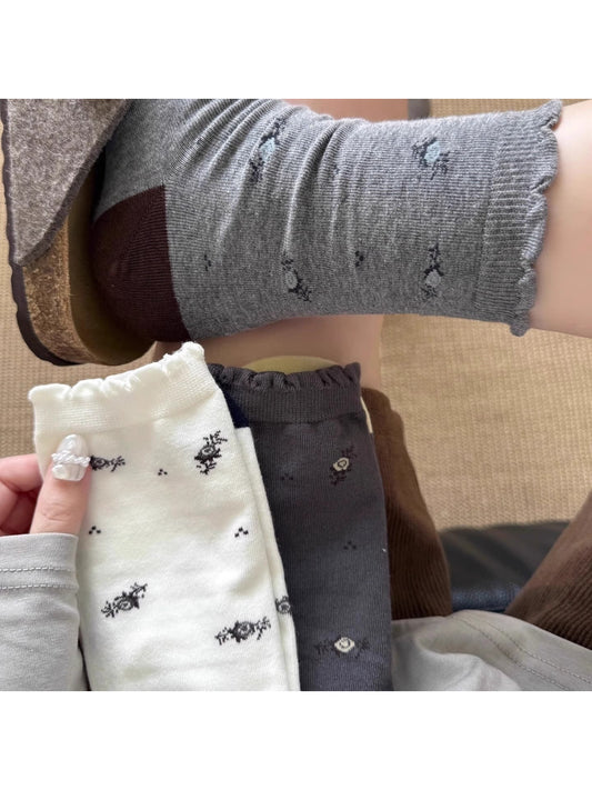Close-up of floral knit pattern on Rufia Classic Crew Socks showing detailed stitching
