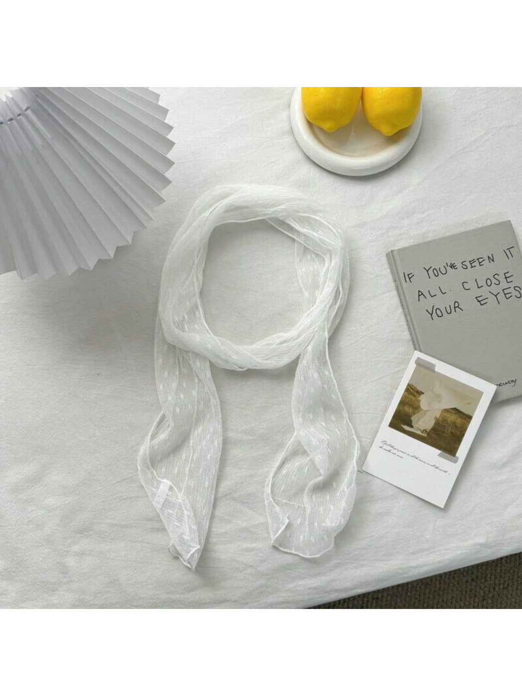 Lightweight dotted neck scarf styled as a headband on a model