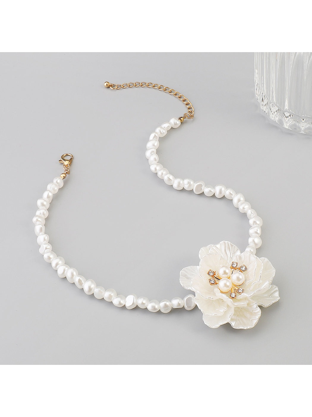 Model styling white beaded flower necklace with casual outfit in natural light