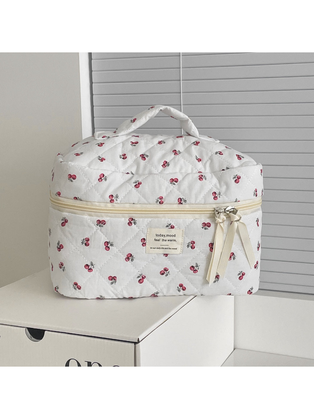Side view of Cosbai cherry print quilted travel makeup bag highlighting stitching details