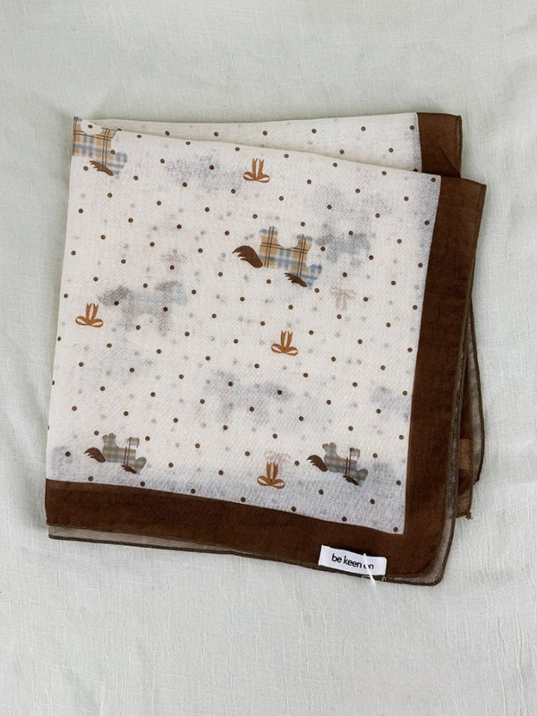 Scarvii Sheer Pony Dot Square Scarf draped over a chair highlighting lightweight sheer fabric