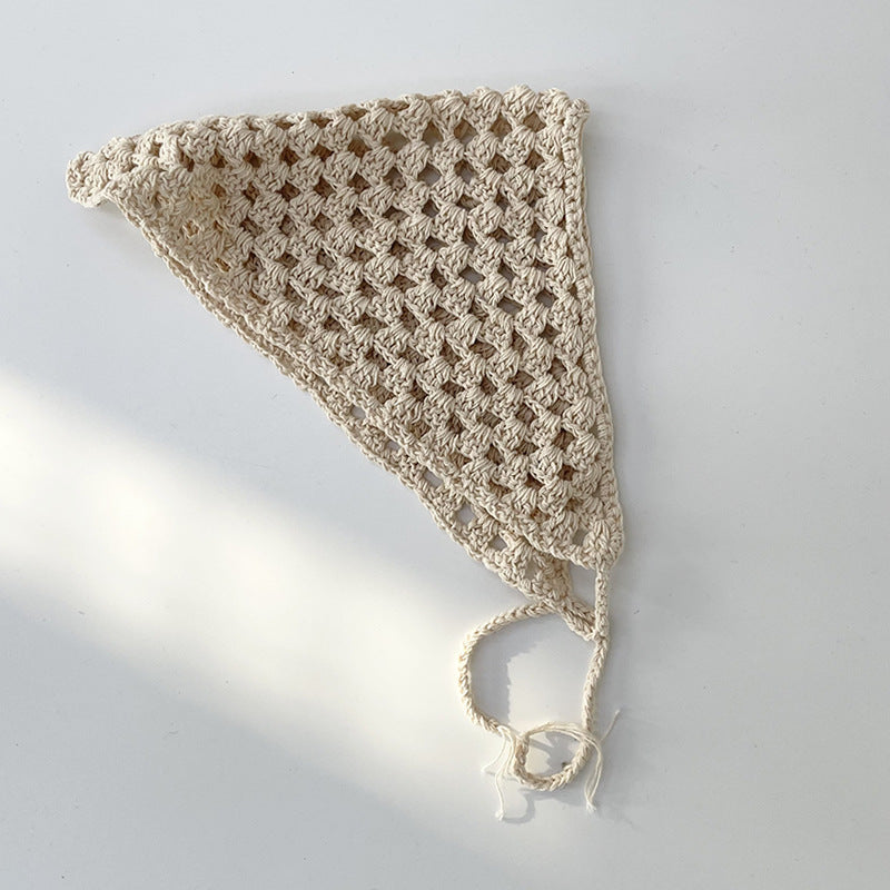 Beige crochet hollow-out hairband folded to show flexibility and texture