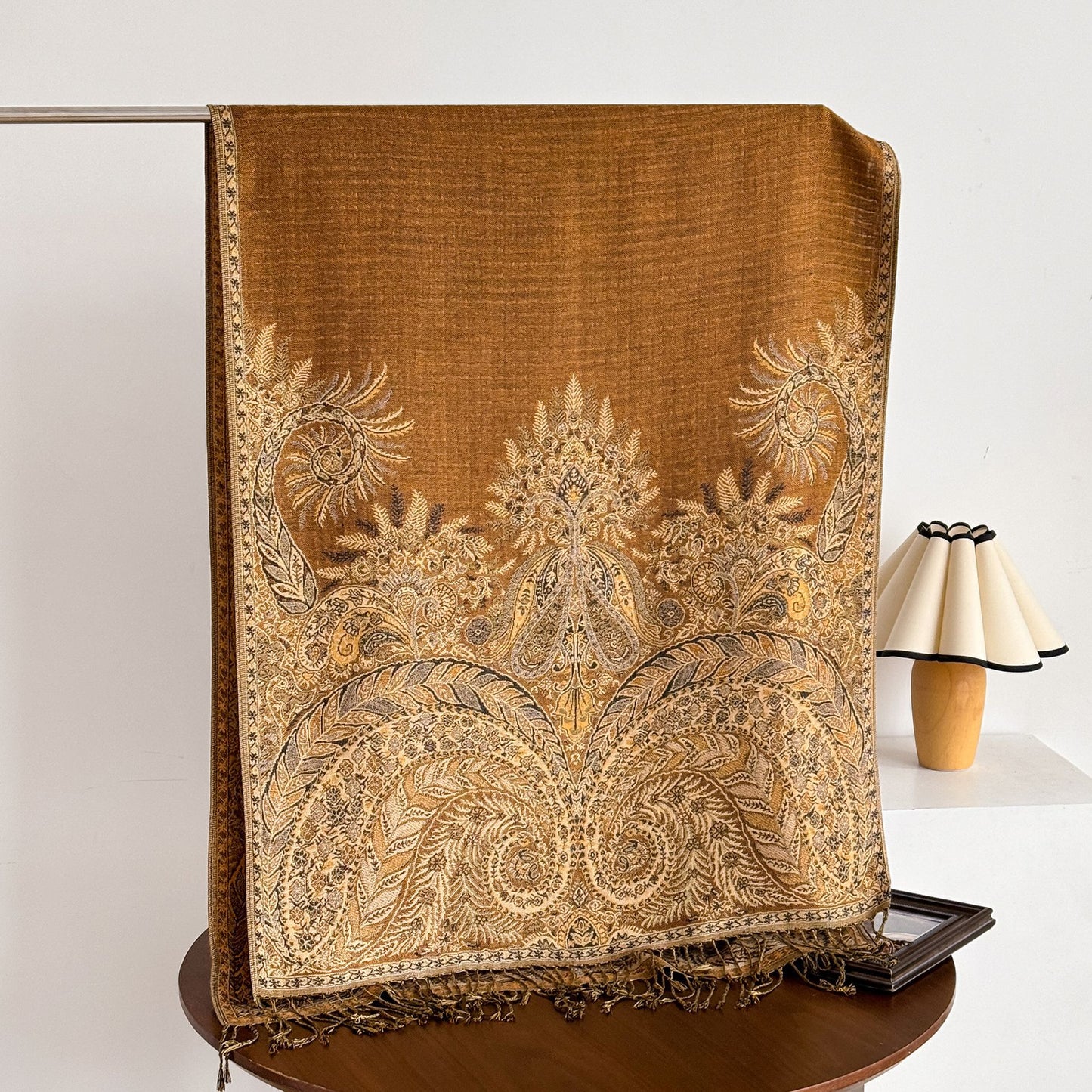 Scarvii scarf folded with tassels spread out on wooden surface