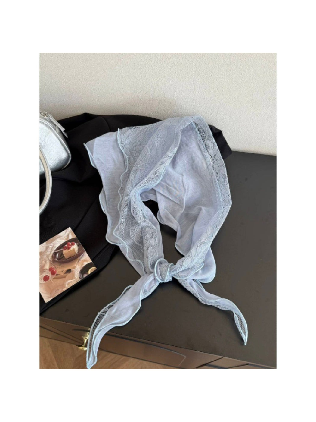 Folded lightweight headscarf showing lace trim and smooth fabric texture