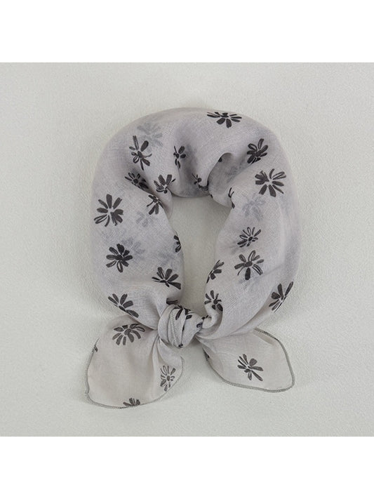 Close-up of Scarvii scarf fabric with small daisy flowers in yellow and white
