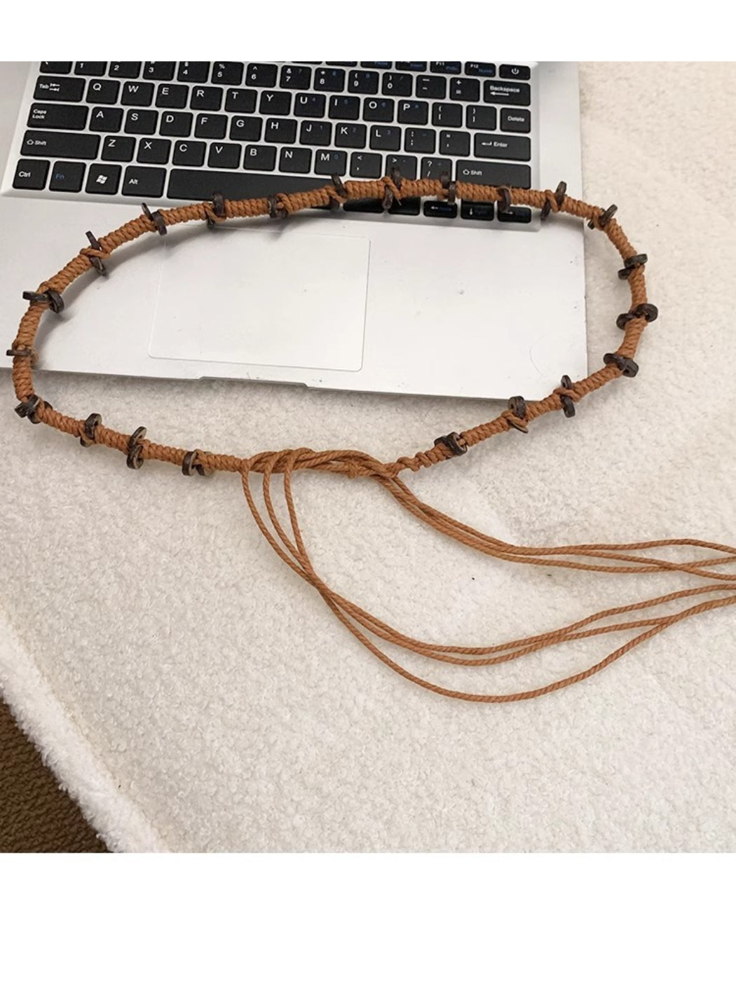 Beco knotted rope belt coiled neatly with visible rope fibers and knot