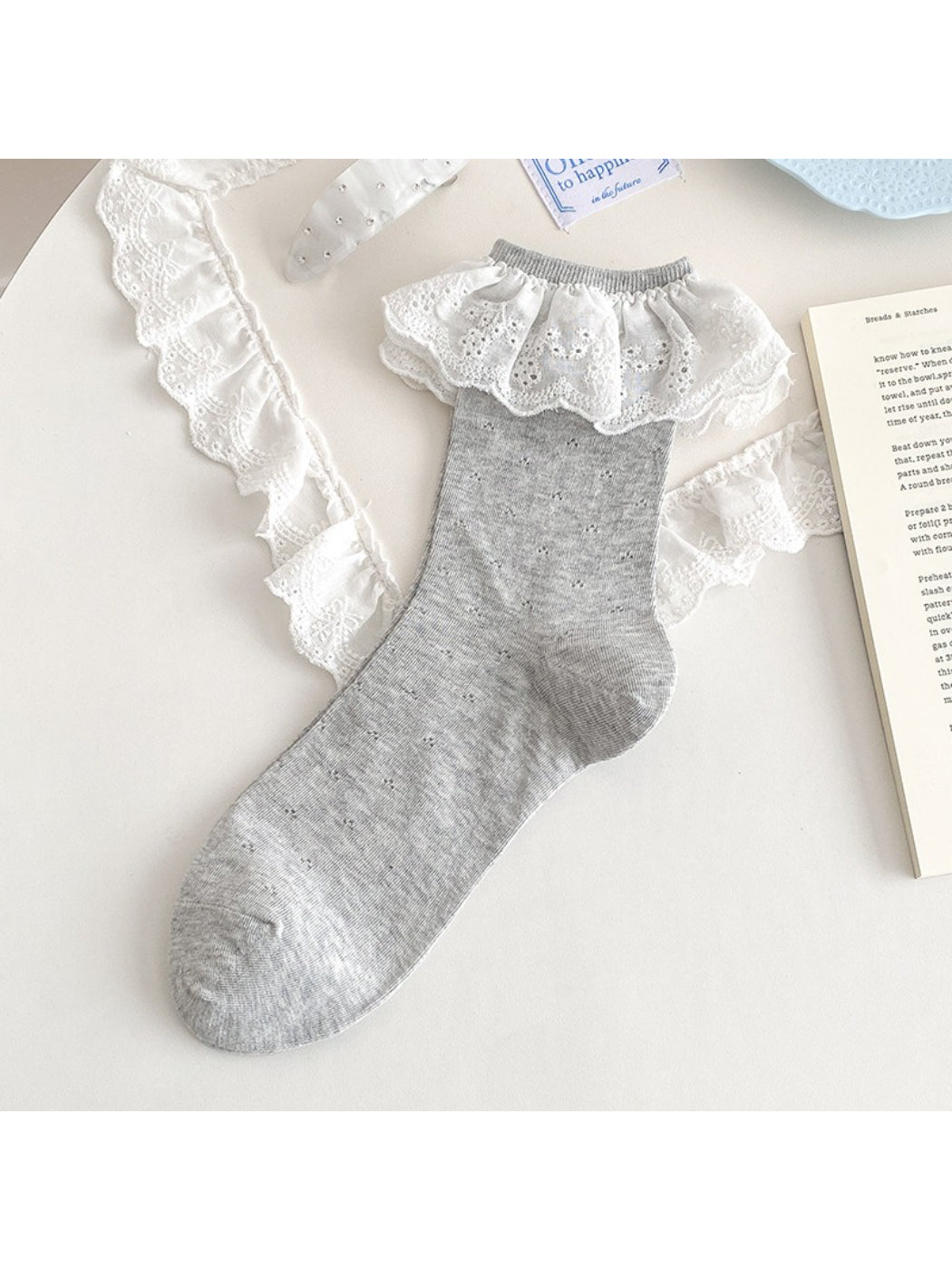 Model seated wearing Rufia lace ruffle trim crew socks with casual outfit
