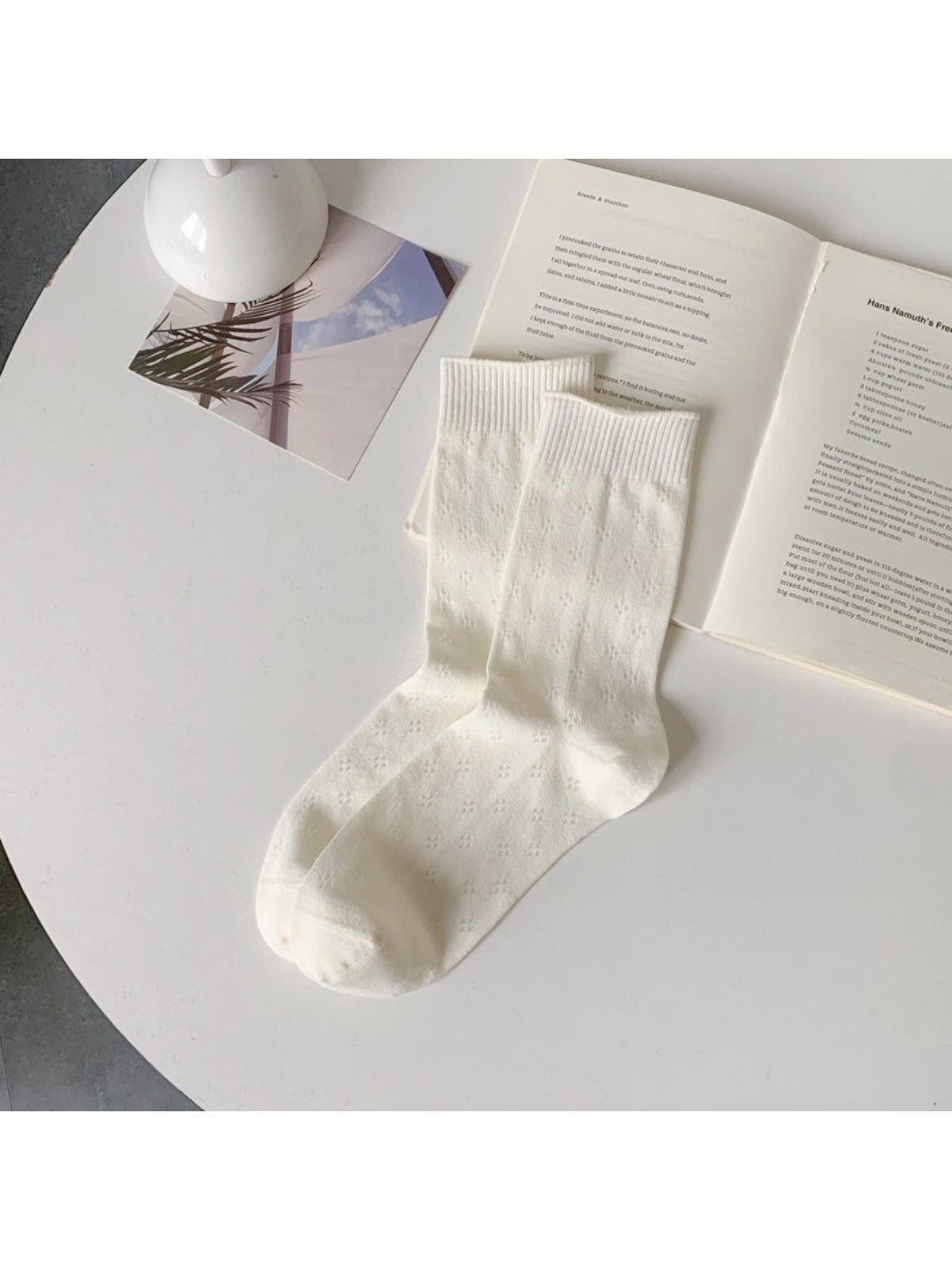 Rufia knit white crew socks arranged in a fan shape on a plain background