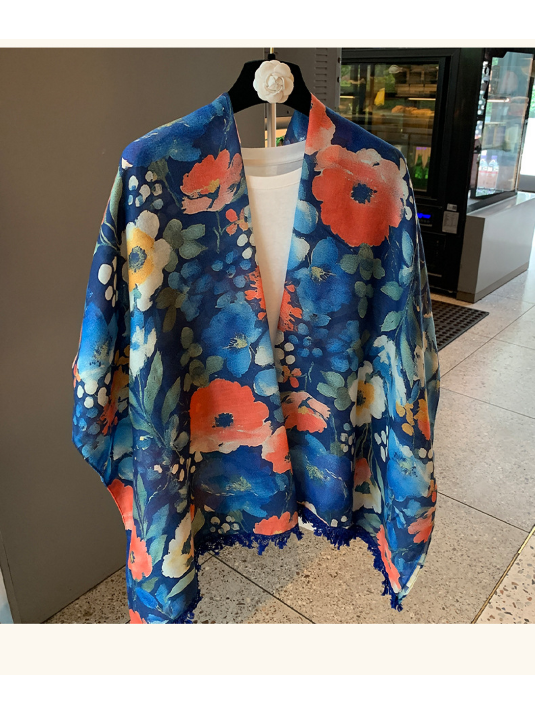 Multicolor floral scarf hanging open over a white top, with one lower end cropped