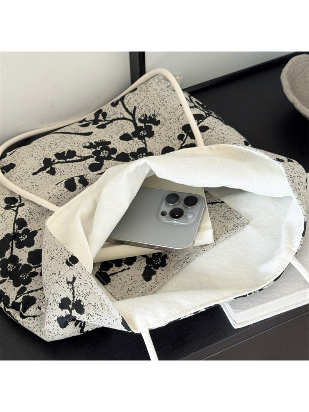 Close-up of the Black tote bag's wide opening and plain ivory interior lining