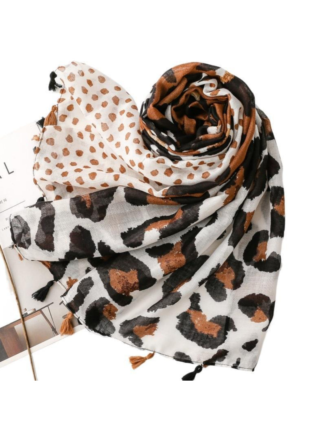 Leopard spot fringe wrap folded neatly highlighting soft fabric and pattern