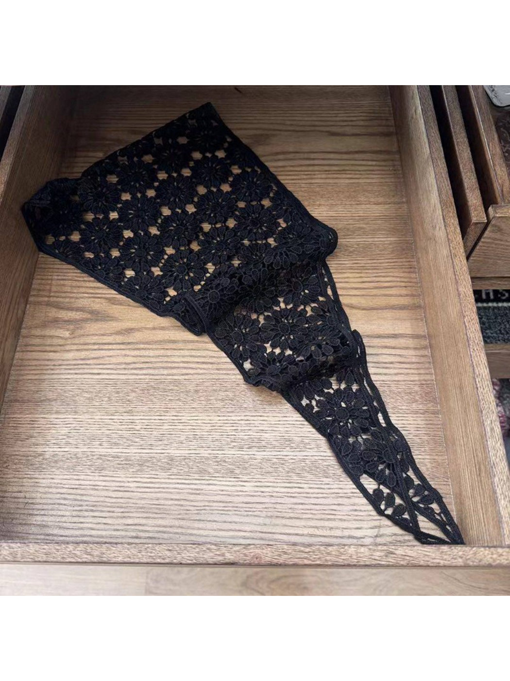 White crochet lace head scarf bandana displayed on wooden surface