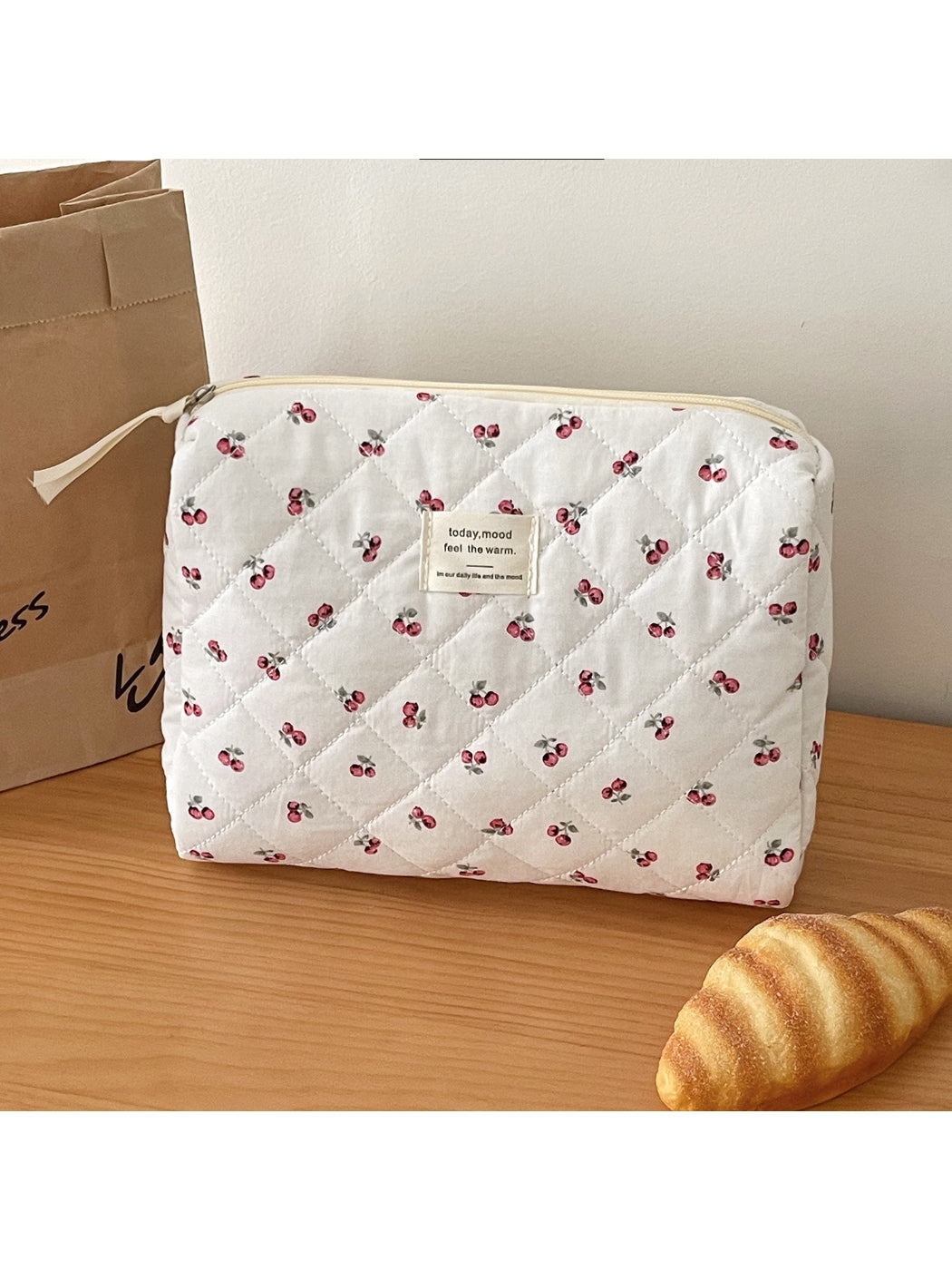 Open view of soft quilted cherry storage pouch showing interior space