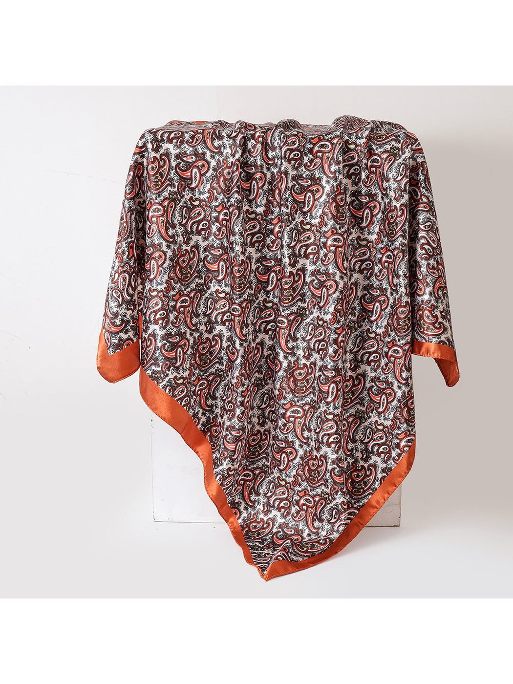 Orange paisley square scarf with a solid border, draped view