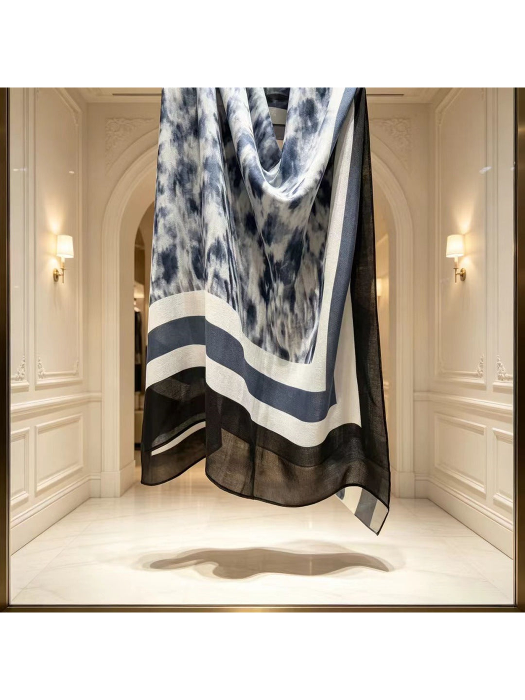 Detail of the scarf hanging in loose folds with a semi-sheer black edge