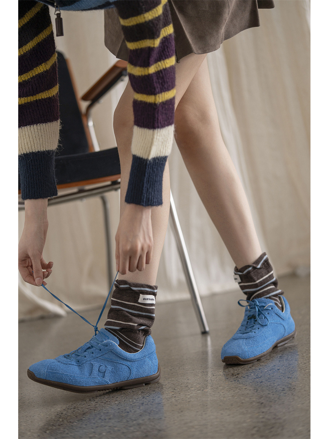 Coffee brown striped socks styled with bright blue shoes