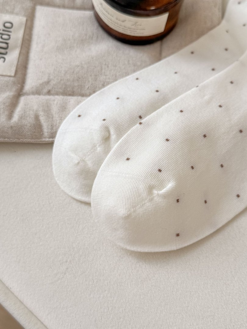 Close-up of the rounded toes and centered toe seams on white dotted socks