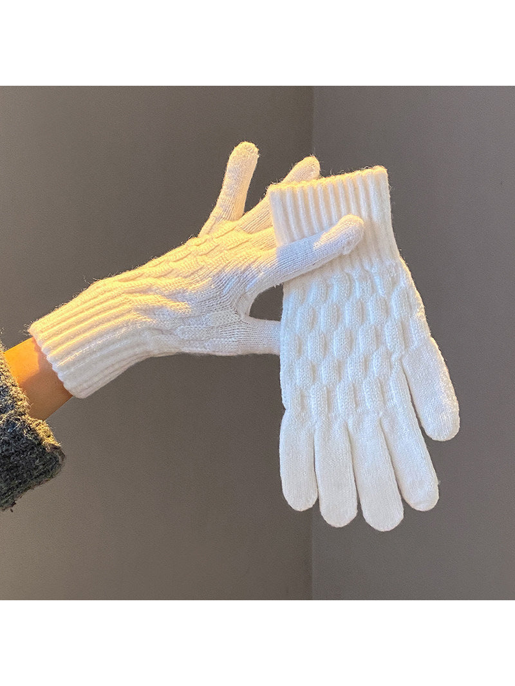 White cable-knit gloves with ribbed cuffs, worn and held view