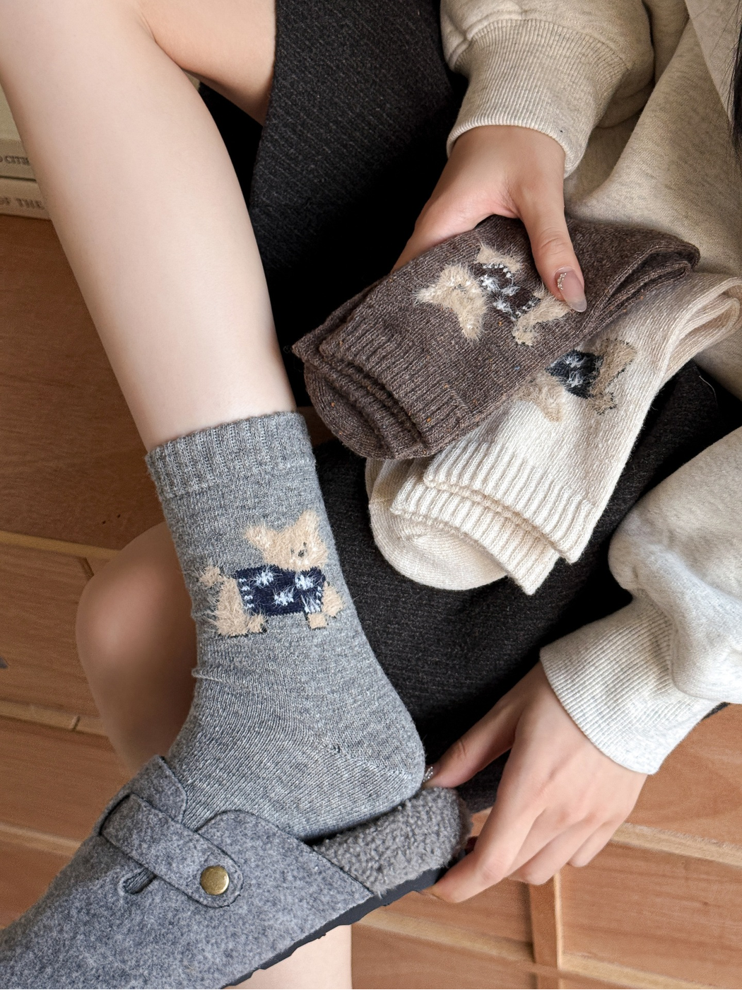 Light gray cat motif crew socks worn with gray slippers
