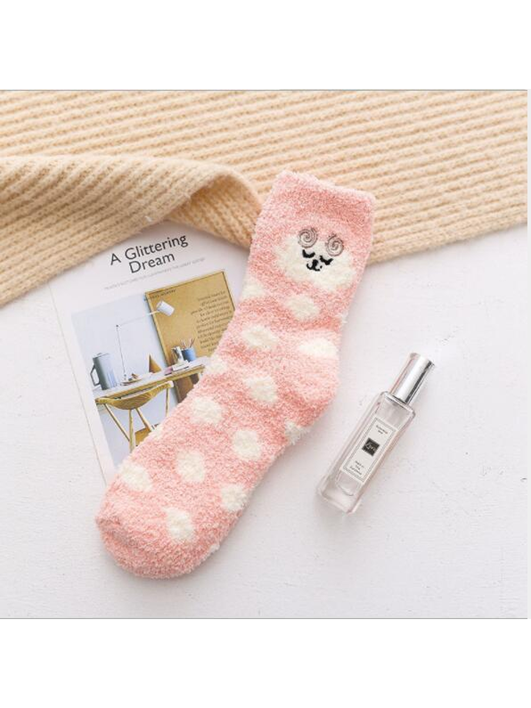 Light pink fuzzy crew sock with cream polka dots and embroidered face motif