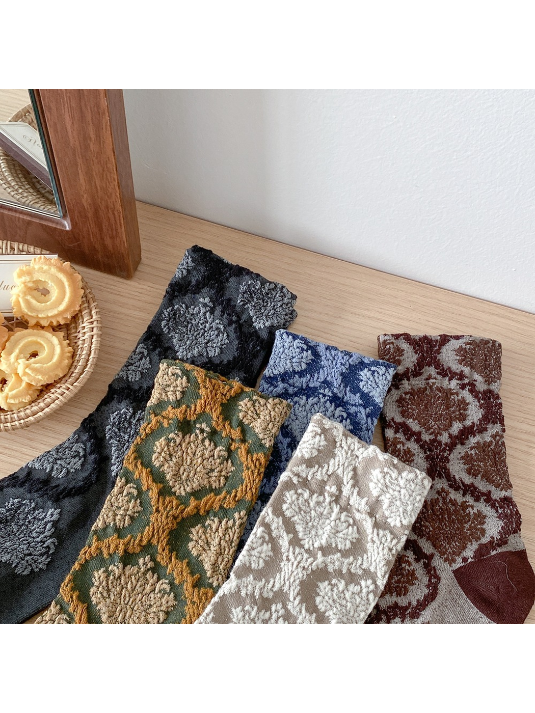 Close-up of raised floral medallion patterns across five sock colors