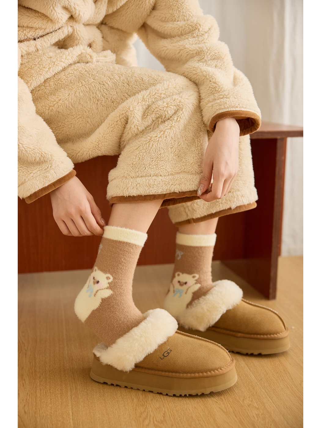 Khaki bear-and-bow crew socks worn with tan slippers