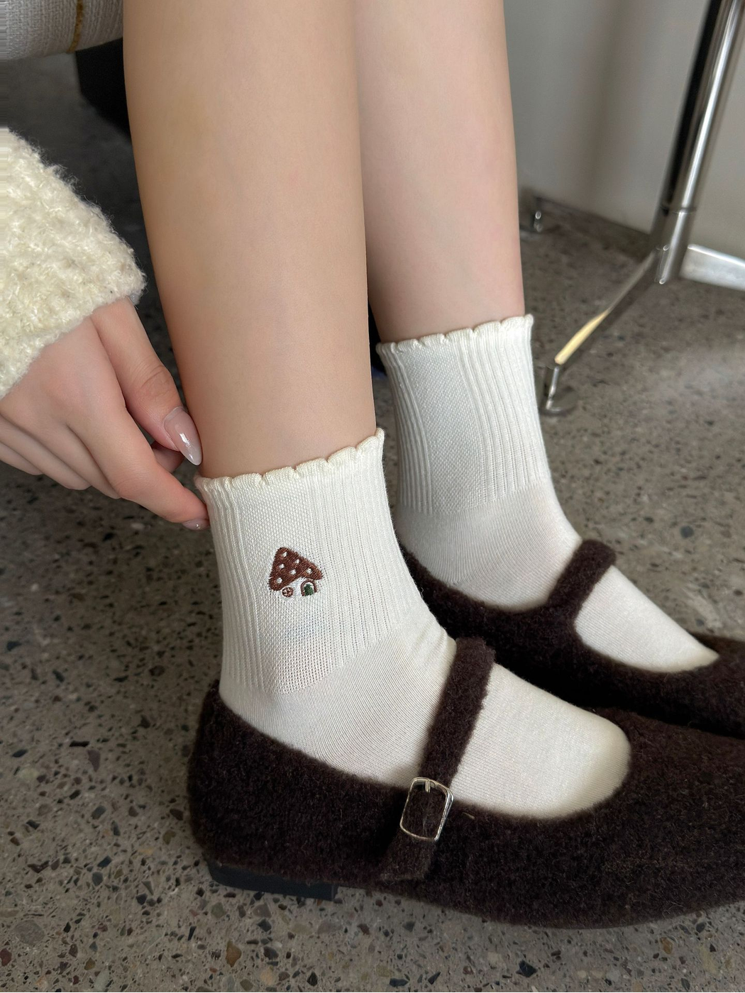 Ivory mushroom-embroidered crew socks worn with fuzzy strap shoes