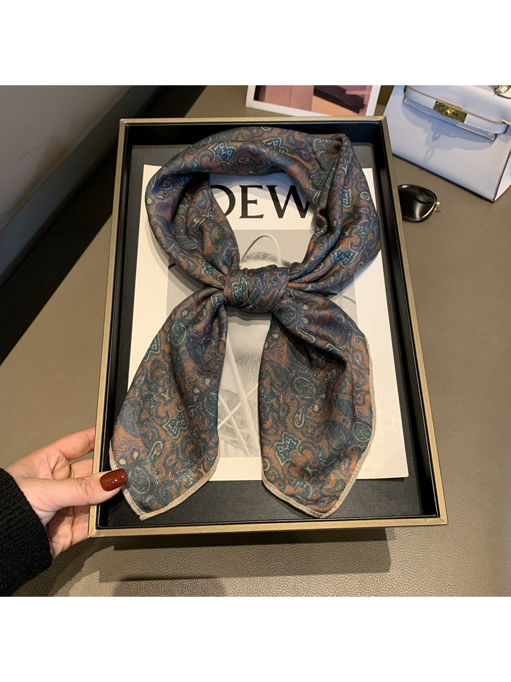 Paisley reverse of the square scarf arranged in a loose front knot