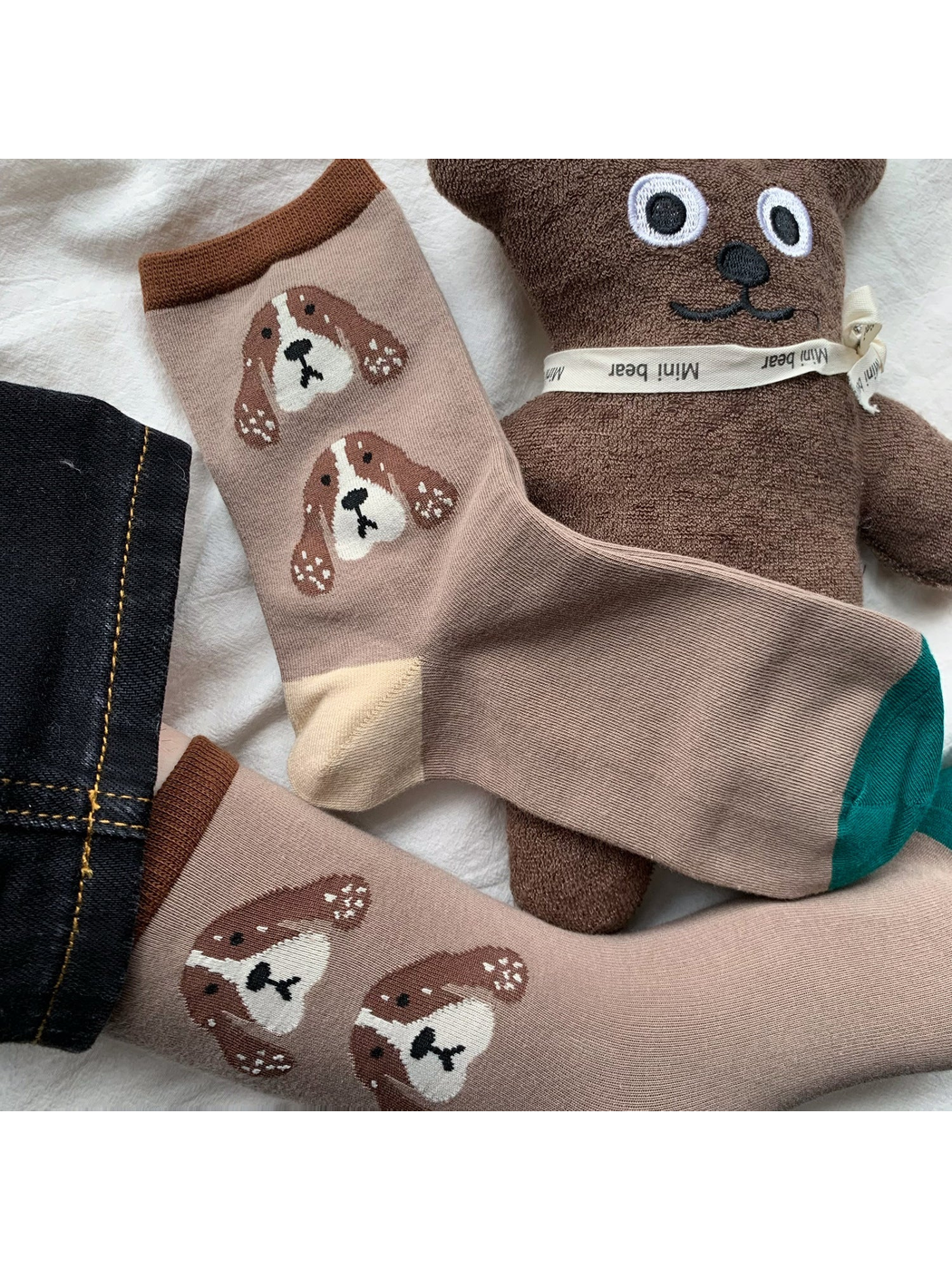Dog crew sock with green toe and repeated dog-face motif