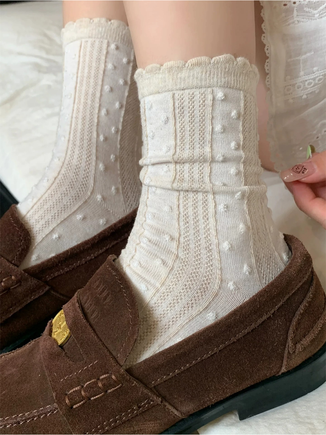 Ivory raised-dot crew socks styled with brown loafers