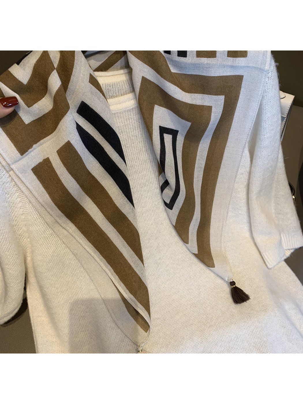 Close-up of the Khaki scarf's geometric pattern and corner tassels