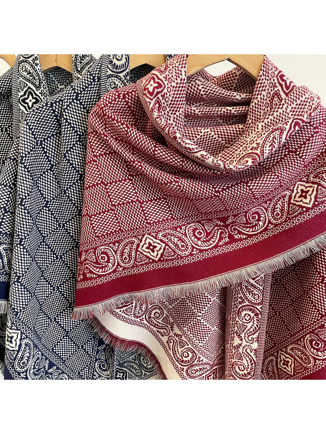 Close-up of Burgundy and Navy geometric scarves with paisley borders and short fringe