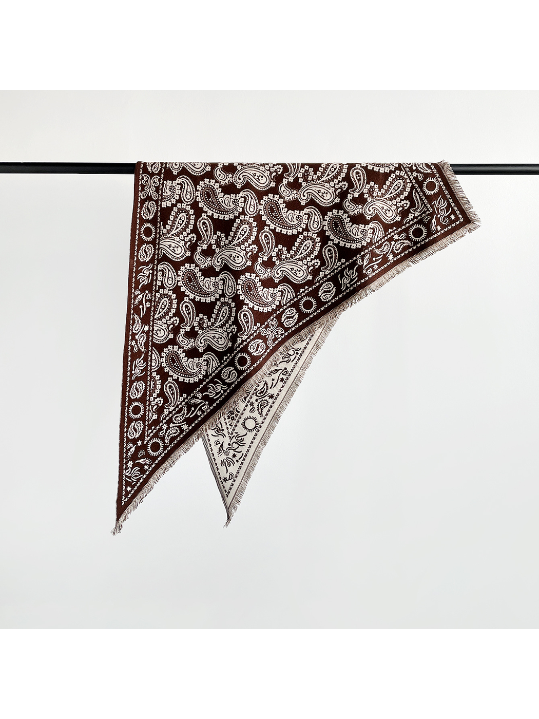 Coffee paisley triangle scarf folded over a display rail
