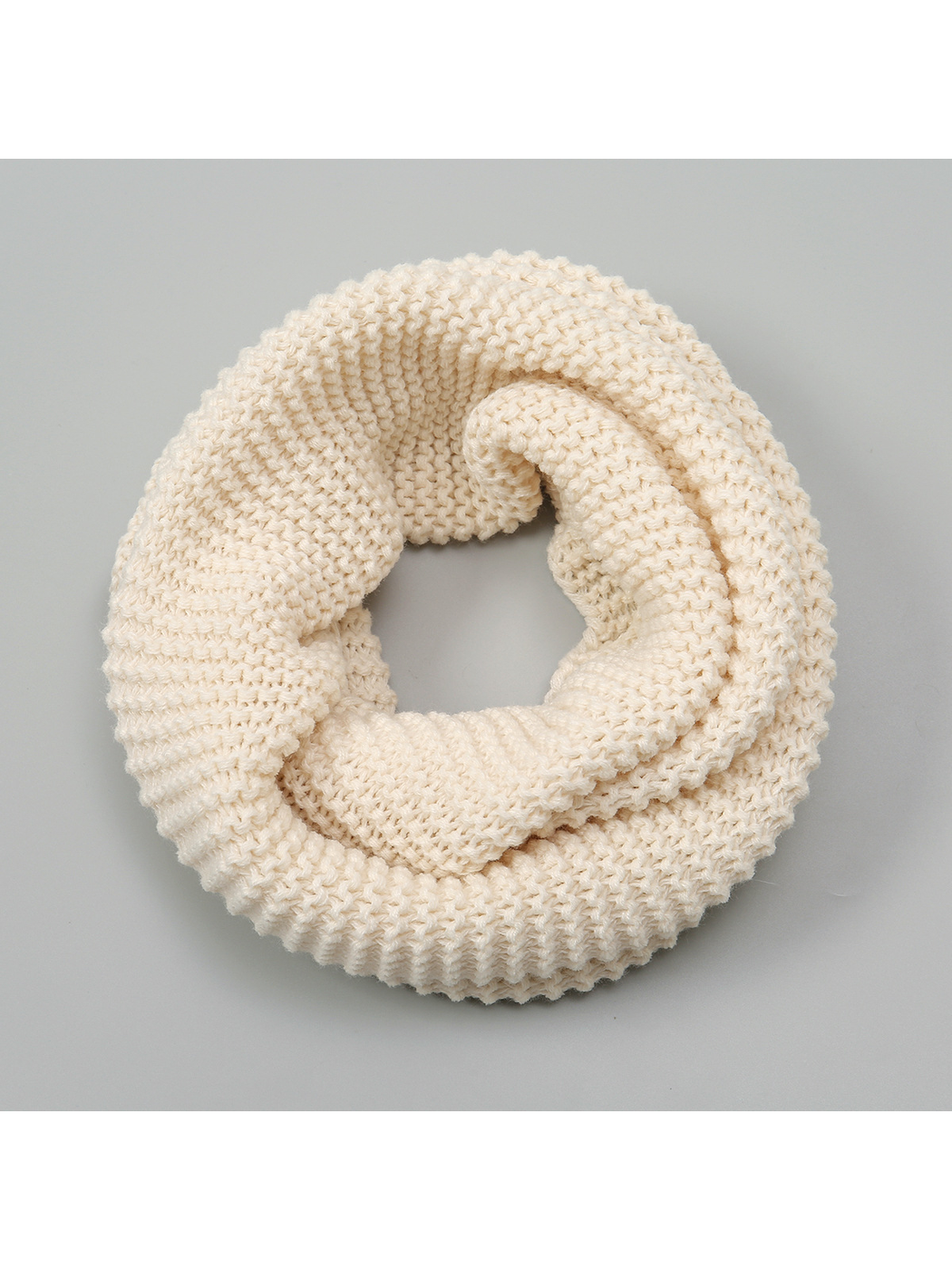 Beige chunky knit infinity scarf arranged in a circular loop