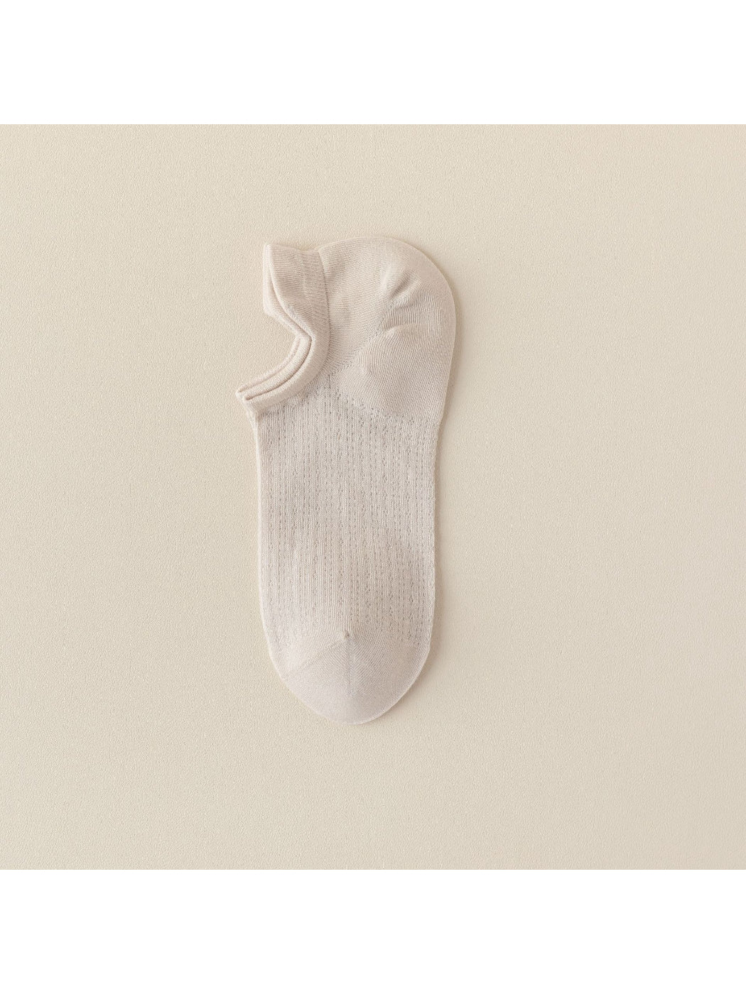 Beige and black Rufia liner socks side by side on white surface