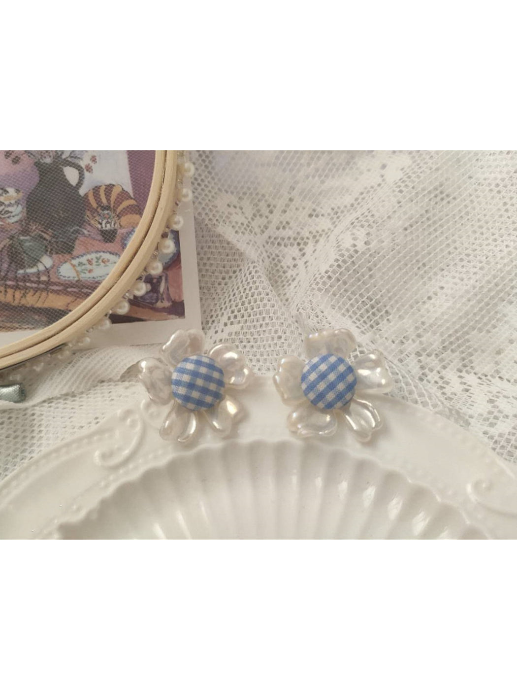 Earwish gingham flower stud earrings worn on a model's ear showing size and fit
