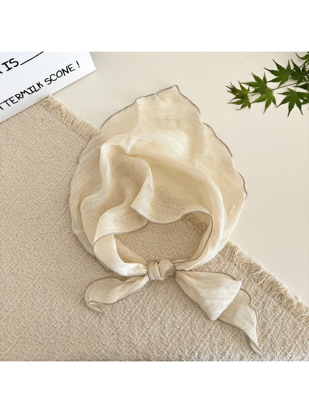 Flat lay of the lightweight solid sheer triangle scarf highlighting its triangular shape