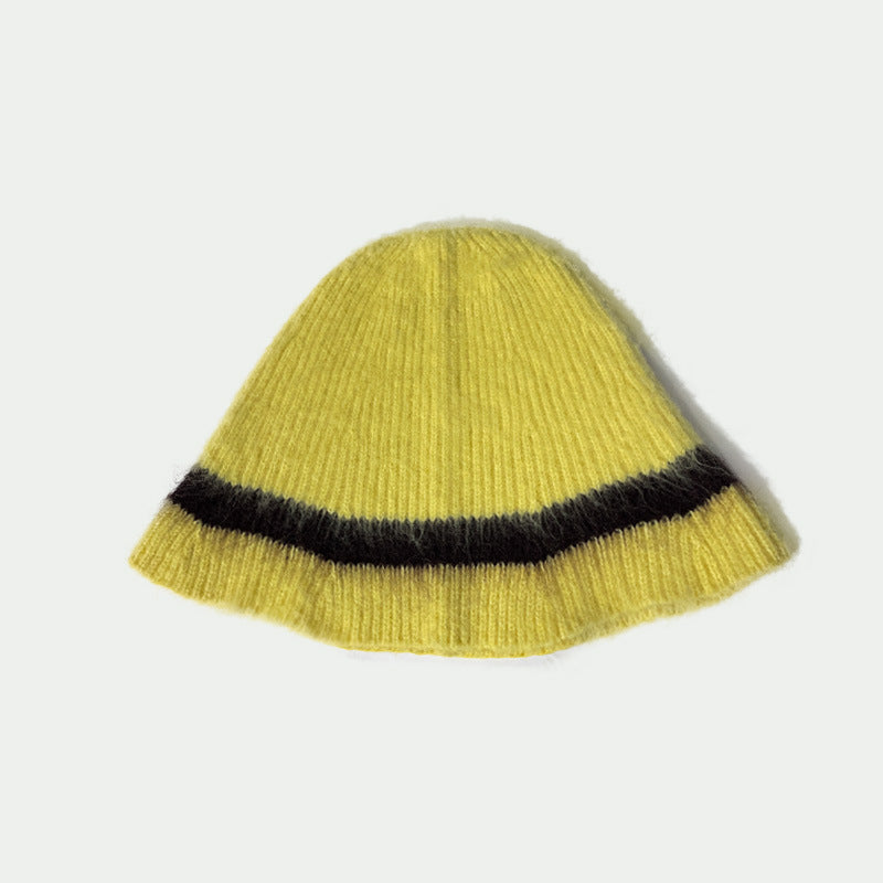 Haila knitted furry bucket hat in beige on flat surface with soft lighting
